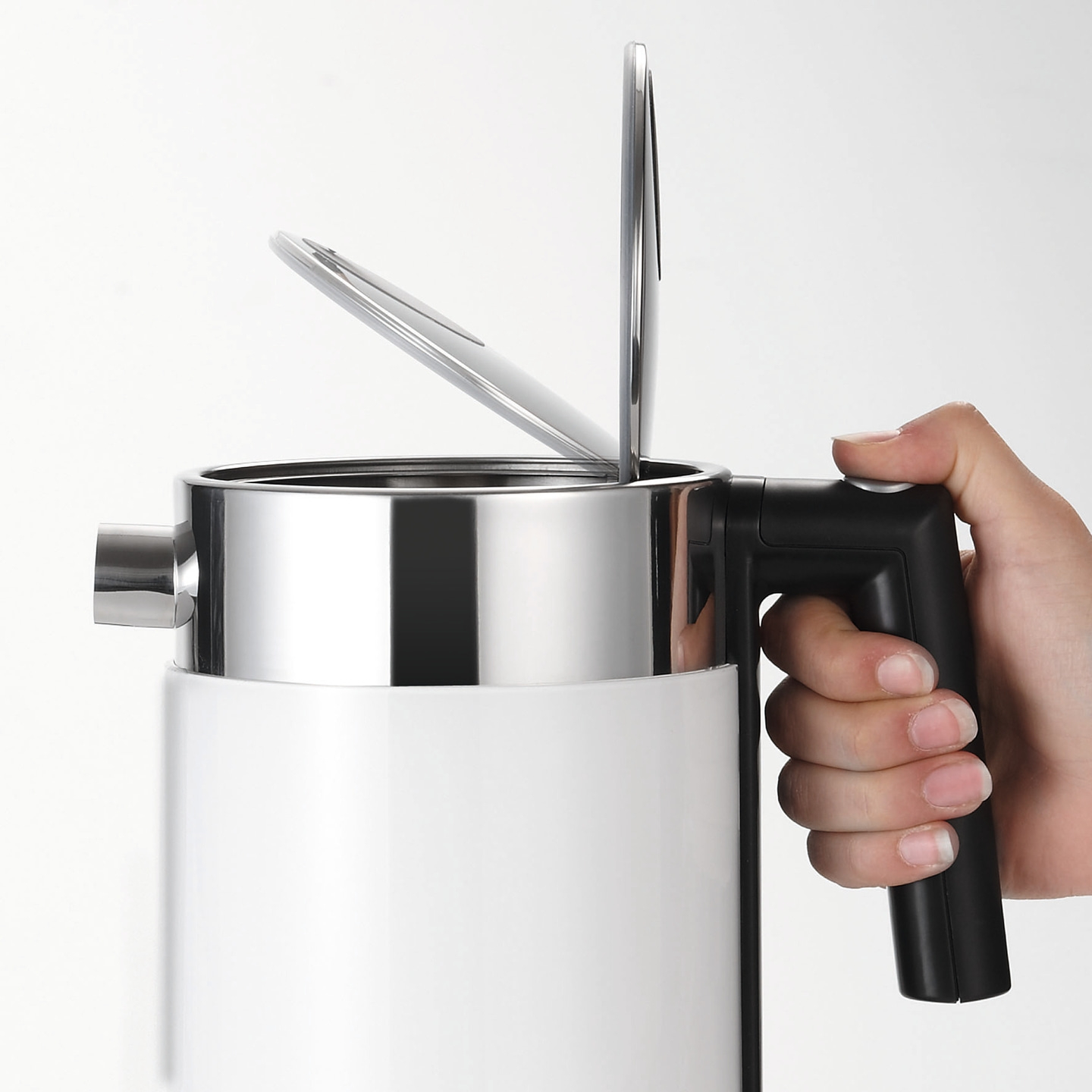 Primo piano di una mano che tiene un bollitore bianco con coperchio aperto, acciaio inossidabile
