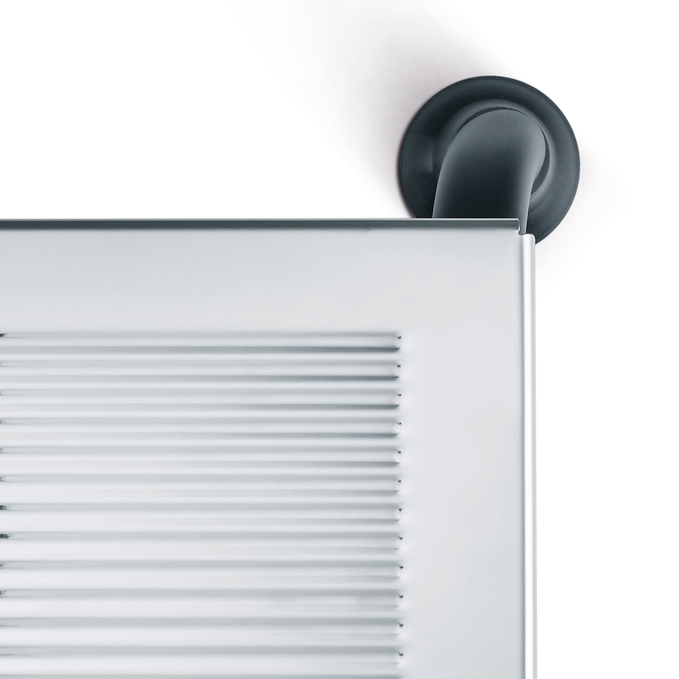 Primo piano di un oggetto argentato con un tubo nero su sfondo bianco.