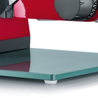 Nahaufnahme eines roten Fleischschneiders mit Glasplatte und Einstellknopf.