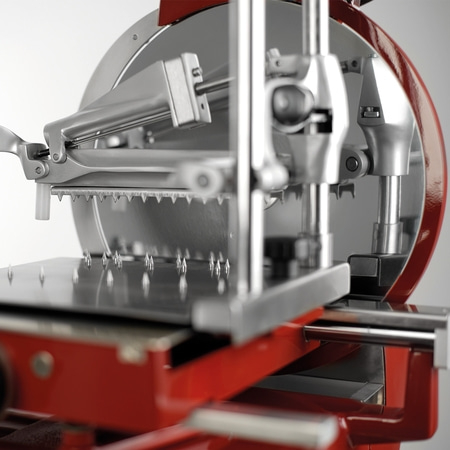 Nahaufnahme einer roten und silbernen Aufschnittmaschine mit gezahntem Messer