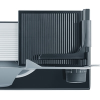 Nahaufnahme eines elektrischen Allesschneiders mit einstellbarem Schlitten und Skala.