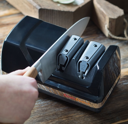 Close-up of a knife being sharpened in a black knife sharpener.