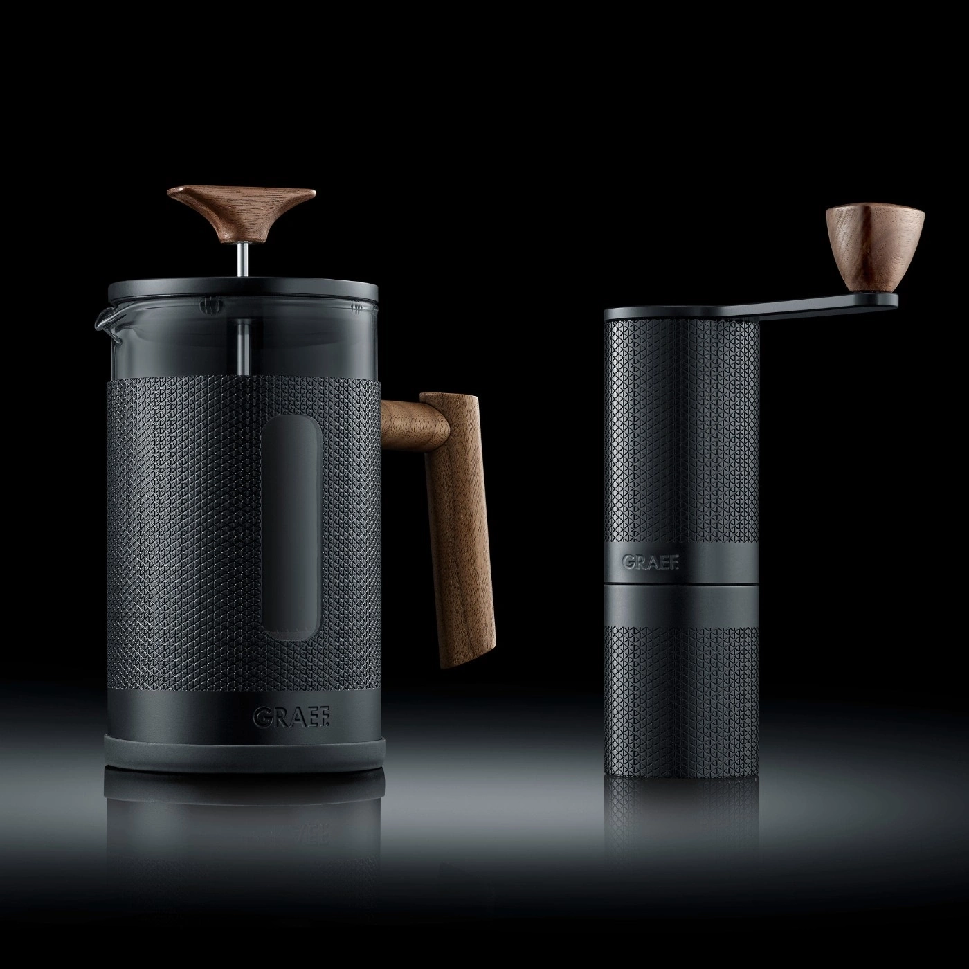Kaffeebereiter und Kaffeemühle in Schwarz mit Holzakzenten auf schwarzem Hintergrund