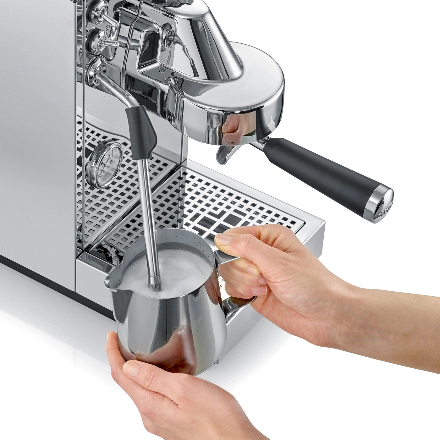 Milch aufschäumen in Milchkännchen mit silberner Siebträgermaschine, weißer Hintergrund
