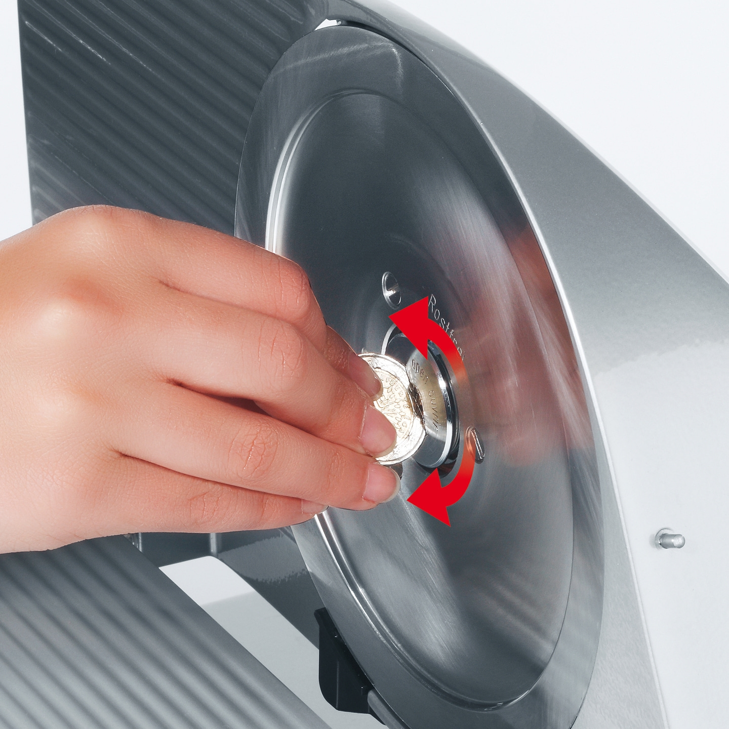 Person is turning a coin in a slicer to unlock the blade, close up shot.