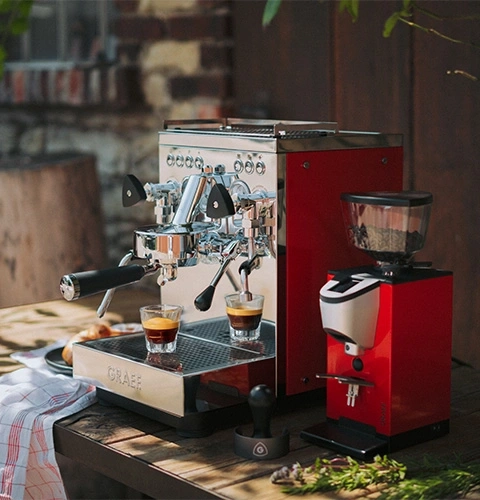 Espressomaschine mit Mühle in Rot und Chrom, zubereitet für Kaffee.