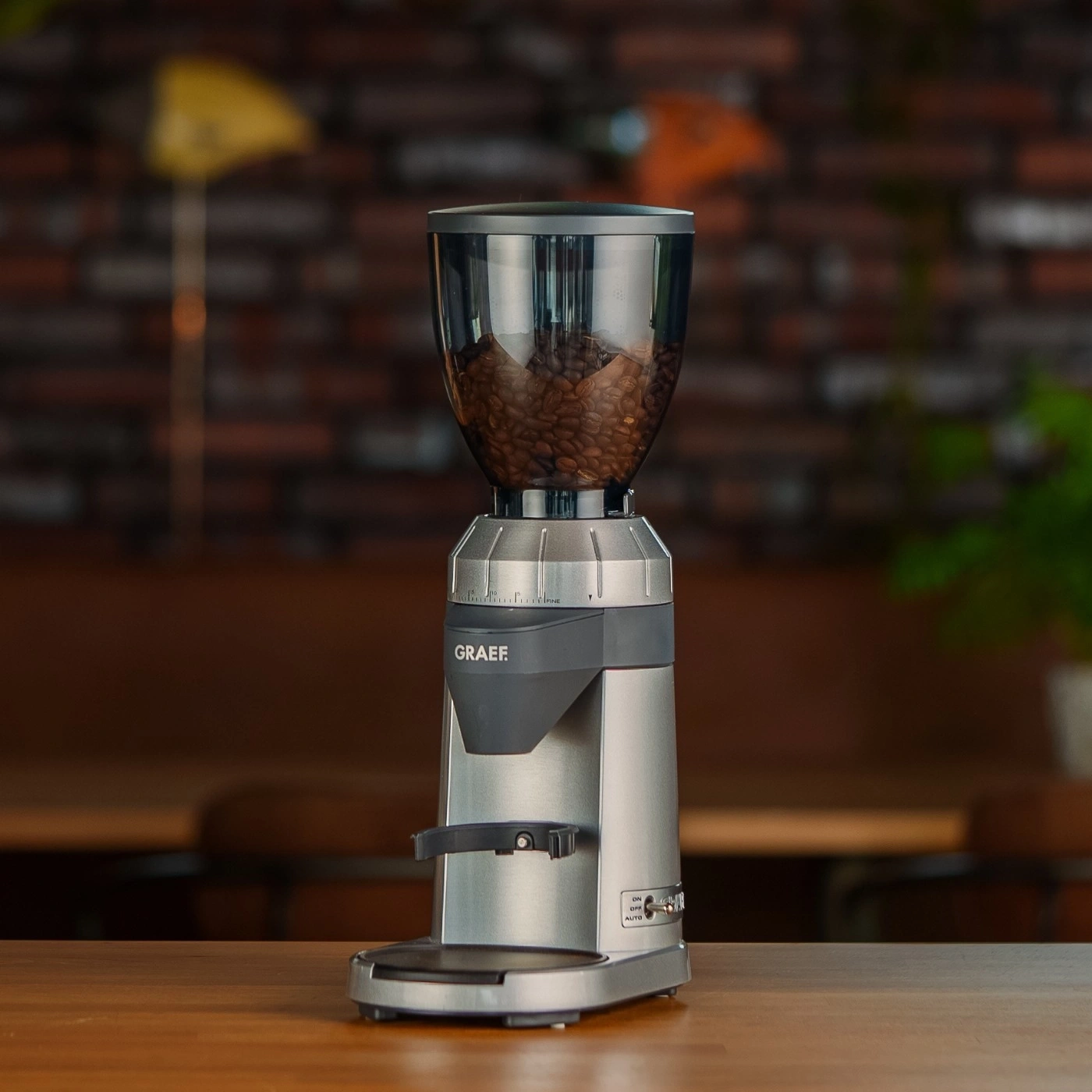 Kaffeemühle GRAEF, silber, mit Kaffeebohnen, auf Holztisch, Nahaufnahme