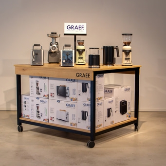 Rolltisch aus Holz mit Produkten und Kartons von GRAEF