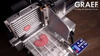 Trancheuse GRAEF avec tranches de salami, préparation culinaire moderne et efficace.