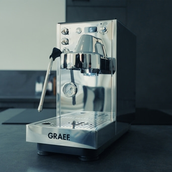 silberne Siebträgermaschine in schwarz weißer Küche