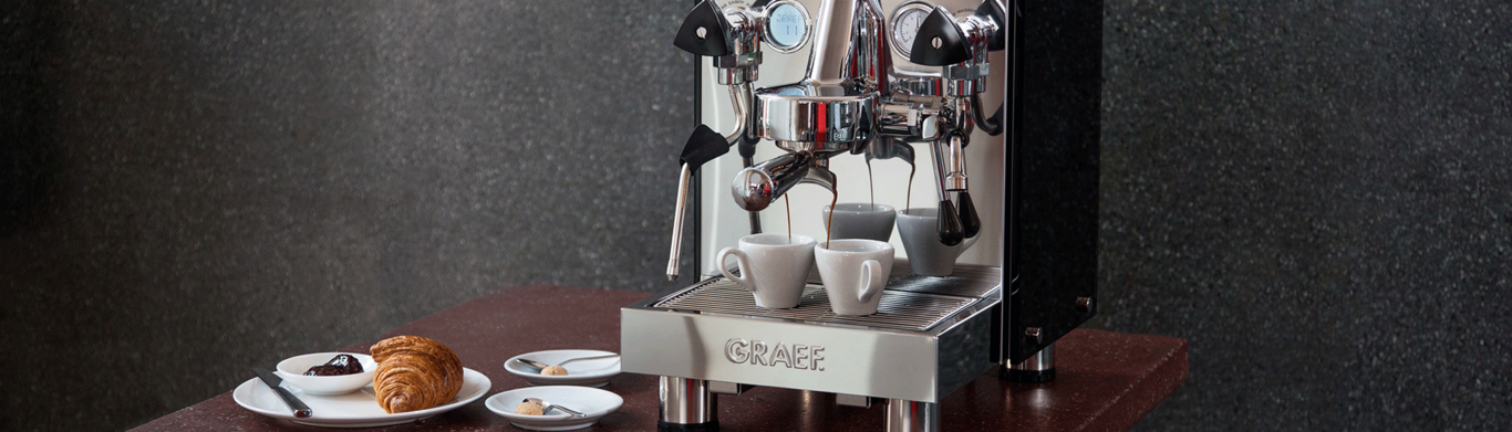 Machine à café avec croissant et pâtisseries sur une table