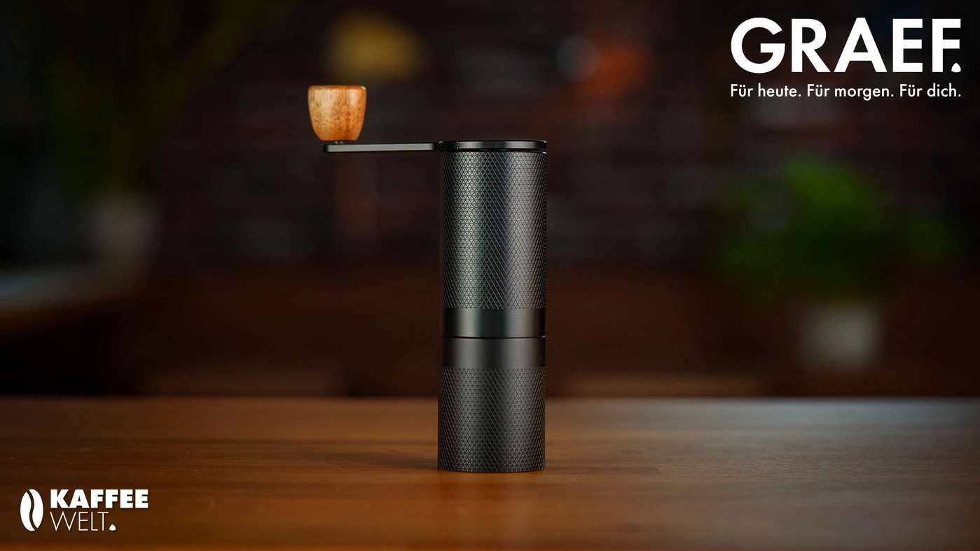 Kaffeemühle von Graef mit Holzgriff auf einem Holztisch.