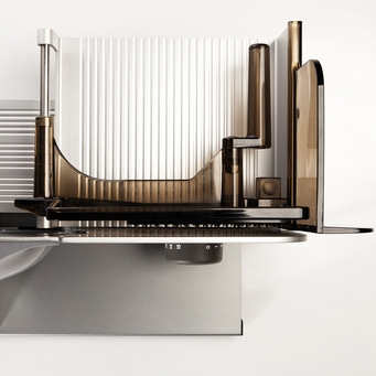 Close-up of an electric meat slicer against a white background