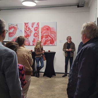 Menschen schauen Kunstausstellung mit dem Thema ,,A Slice of Art" an