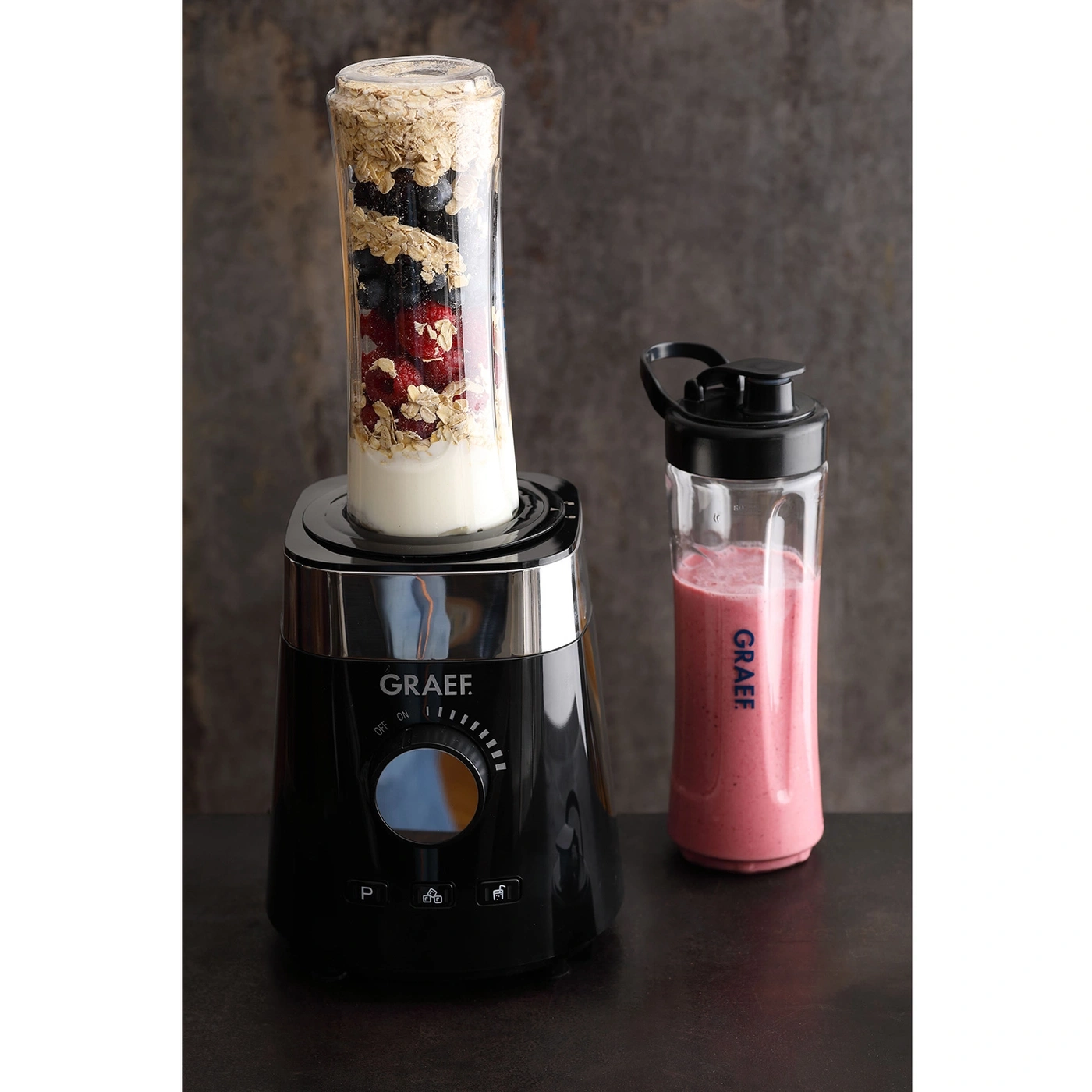 Mixer mit Zutaten und fertigem Smoothie in einem Glasbehälter