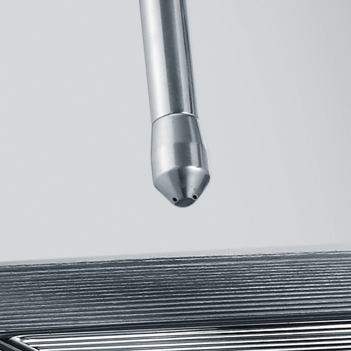 Metallrohr mit Düse, die auf eine Reihe von Metallplatten gerichtet ist
