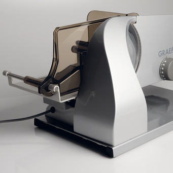 Silver Graef slicer with safety guard and adjustment dial, close-up shot