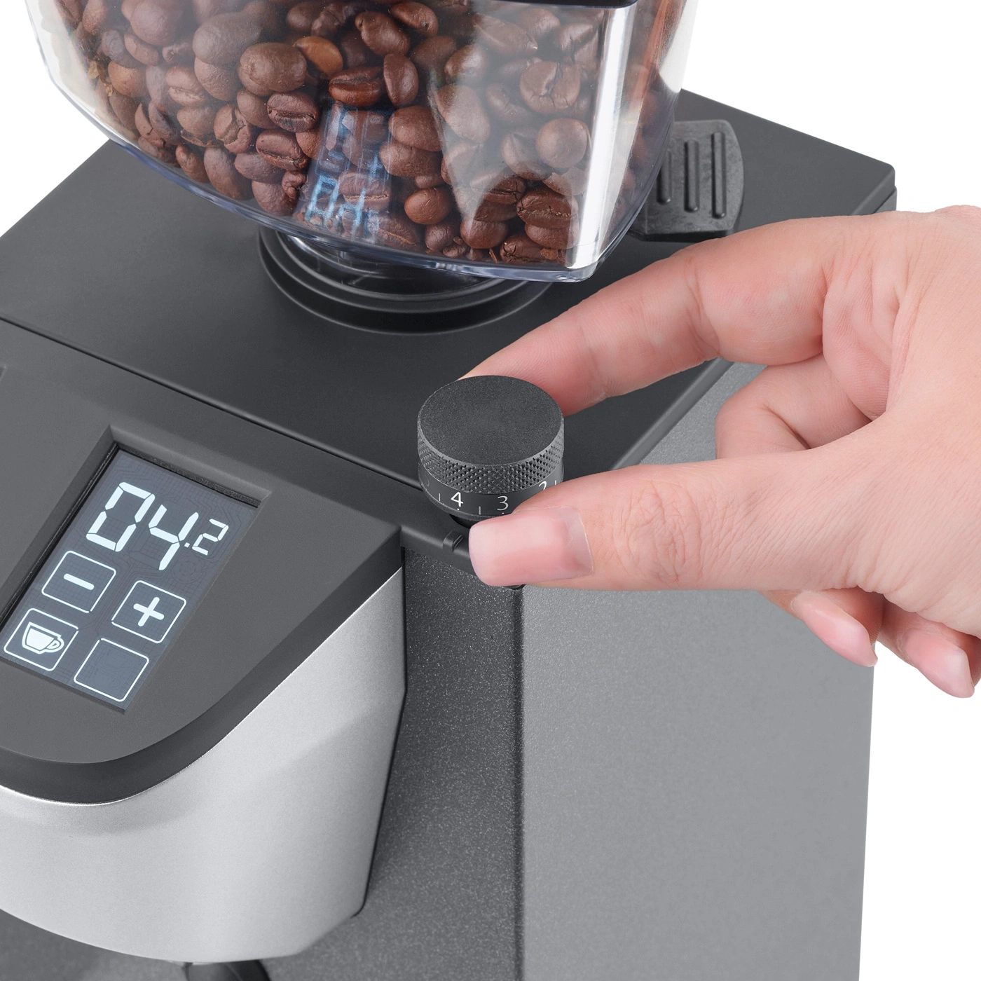 Kaffeemühle mit Kaffeebohnen und Hand, die den Knopf dreht, Nahaufnahme