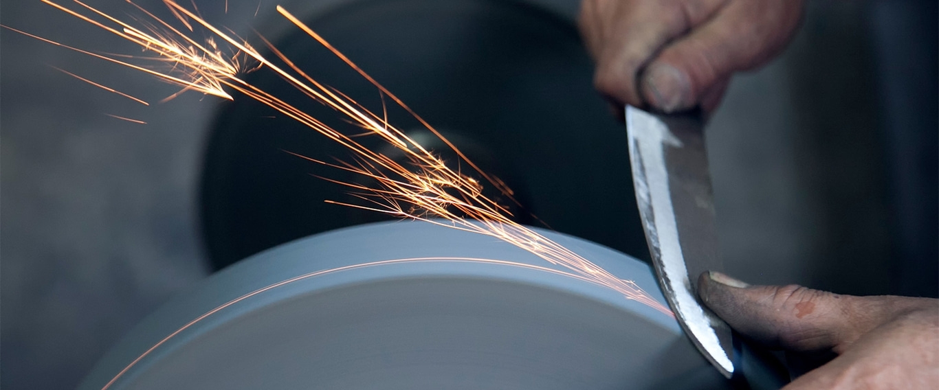 Messer wird geschärft, Funken fliegen, Nahaufnahme, Handwerker, Werkzeug, Metall